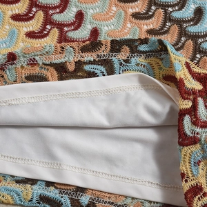 Gros plan sur le tissu en dentelle colorée avec doublure blanche et finitions soignées