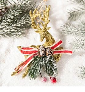 Detail of glitter golden reindeer ornament with pine cones, berries, and festive bow