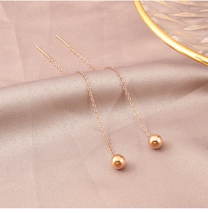 Macro detail of 18K gold plated heart drop long fringe tassel earrings on silk