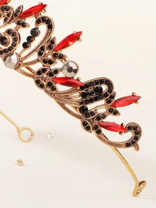 Vue macro détaillée d'une couronne dorée vintage avec gemmes rouges et strass noirs