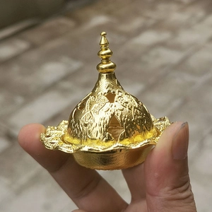 Détail du couvercle du brûle-encens en métal doré avec motifs sculptés complexes