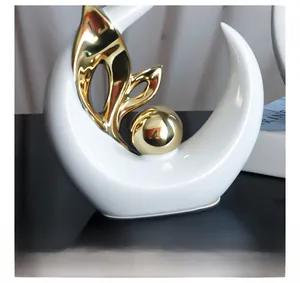 Detail of white ceramic sculpture with gold plated leaf and abstract sphere elements