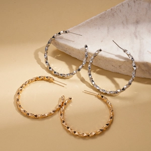 Polished gold and silver geometric C-shaped hoop earrings with faceted diamond texture