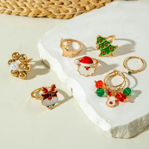 Détail d'un lot de bagues de Noël avec rennes et Père Noël sur support en pierre