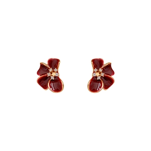 Vintage flower earrings with red enamel petals and zircon centers on a clean white background