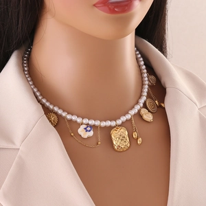 Baroque faux pearl necklace featuring vintage gold charms on an elegant model
