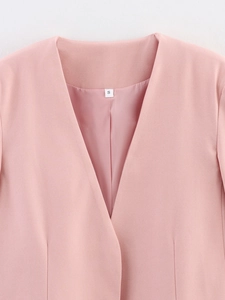 Dettaglio del collo del blazer rosa senza colletto, cuciture e texture con etichetta S