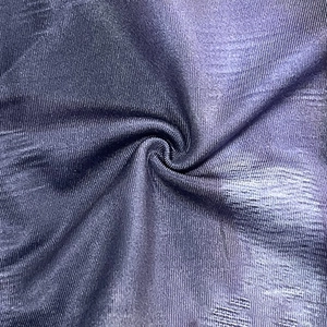 Macro detail of dark purple ribbed fabric showing soft texture and premium silk finish