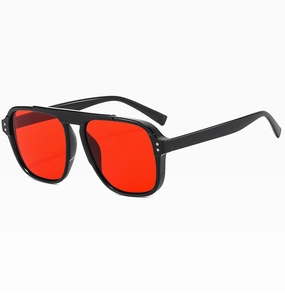 Detail view of oversized retro sunglasses with black frames and vibrant red lenses
