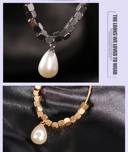 Macro view of geometric titanium steel necklace with drop pearl charms in gold and silver