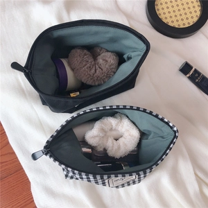 Close-up of black and checkered canvas cosmetic bags showing spacious interior and lining