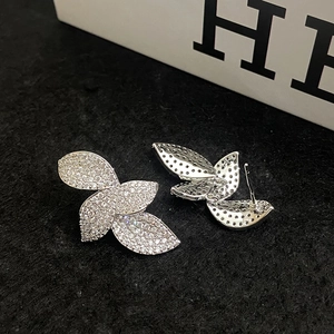 Gros plan détaillé de boucles d'oreilles feuilles en argent avec cristaux scintillants