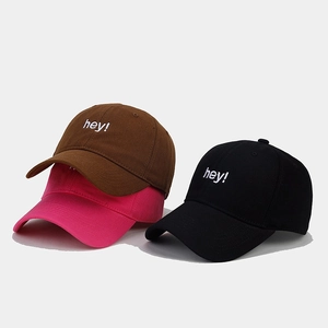 Close-up of three 6-panel baseball caps in brown, rose, and black with hey embroidery