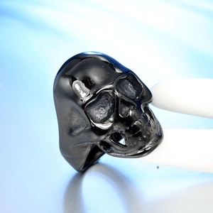 Macro shot of punk style skull ring showing detailed skeletal texture and shiny black finish