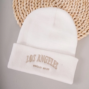 Gros plan détaillé de la broderie Los Angeles vintage sur un bonnet en maille blanche