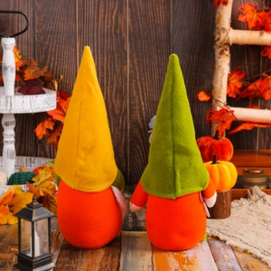 Set of two orange autumn Christmas gnomes with yellow and green hats on rustic wood background