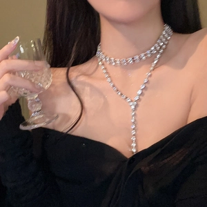 Double-layered silver Y-necklace with rhinestone square fringe on a female model