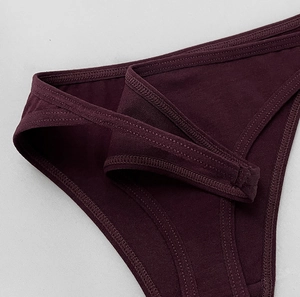 Detailed close-up of dark purple cotton thong showing elastic waistband and ribbed texture