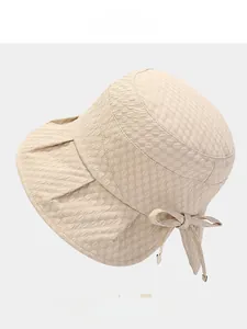 Detail of fabric texture on a beige sun hat featuring a bow and four available colors