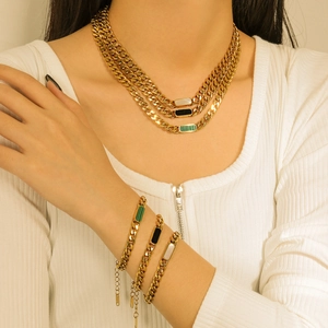 Detail of 18K gold-plated layered chain necklaces with malachite and shell inlay