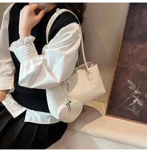 Détail du sac à bandoulière en cuir blanc crème avec un pendentif en forme de cœur