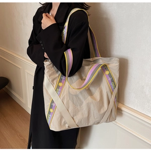 Détail du grand sac cabas beige avec ses larges bandoulières aux motifs géométriques