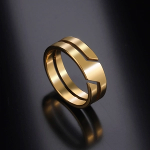 Close-up of golden stainless steel ring with double-layer split design on reflective surface