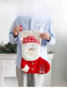 Grosser gestrickter Weihnachtssocke Detail mit Weihnachtsmann Design und festlicher Freude.