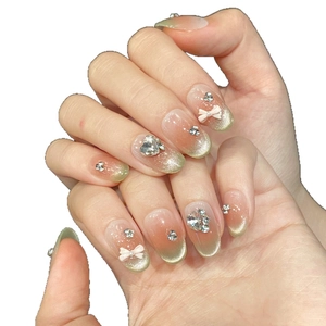 Cat eye green and peach pink gradient press-on nails with 3D bows and rhinestones