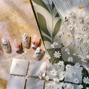 3D embossed daisy nail art stickers with white flowers and green leaves on purple base