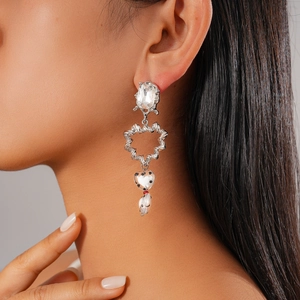 Détail de boucle d'oreille cœur torsadée à pois noirs sur mannequin sous lumière douce