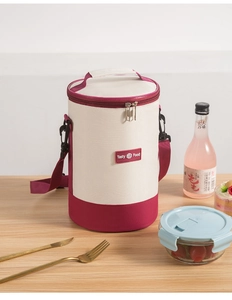 Detailed view of insulated cylindrical lunch bag with shoulder strap and canvas texture