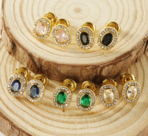 Detail view of four pairs of oval gold earrings with colorful stones and rhinestones