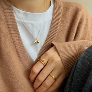 Detail of 925 silver necklace with gold and silver bead pendants and gold rings