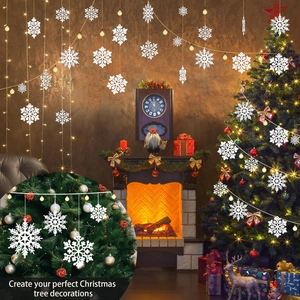 White snowflake hanging decorations on a decorated Christmas tree with warm festive lighting