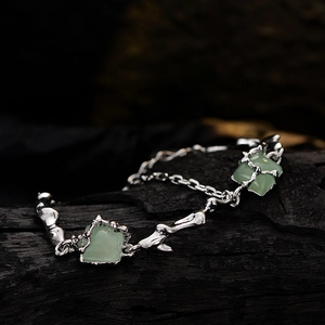 Silver lava style bracelet with green aventurine stones on a charcoal background