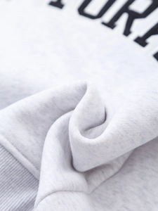 Macro detail of heather gray velvet sweatshirt fabric with black letter embroidery