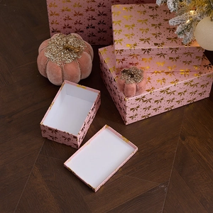 Pink Christmas gift boxes with gold bows and velvet pumpkins for festive scene decoration