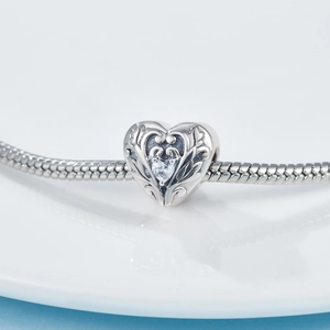 Foto macro de charm de corazón en plata S925 con diseño calado y cristal brillante en pulsera