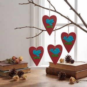 Close-up of heart-shaped hanging ornaments with bird motif and HOME text on dry branches