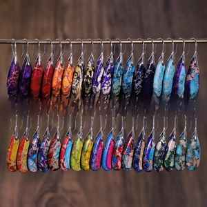 Detailed view of colorful teardrop natural stone earrings with marble texture on display