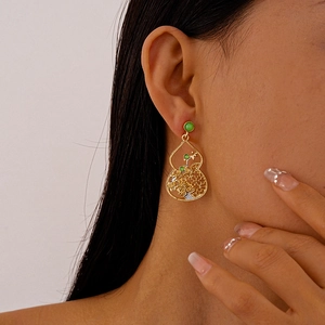 Close-up of hollow gourd earrings with green jade beads on a model for a vintage look