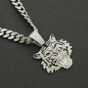 Close-up of iced out tiger head pendant in silver finish with sparkly rhinestones
