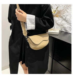 Chic beige saddle bag with broad FASHION letter strap shown on female model