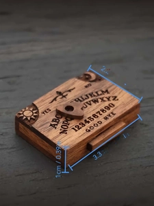 Detailed view of miniature wooden spirit board showing engraved moon and star symbols