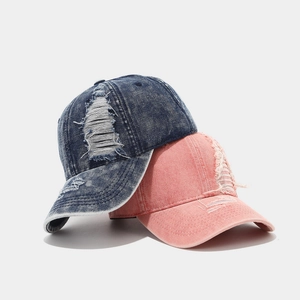 Distressed vintage denim baseball caps in navy and pink with stylish ripped details