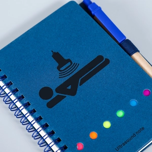 Blaues Spiralnotizbuch für Ultraschall mit Stifthalter und bunten Punkten auf dem Cover