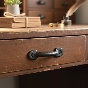 Vintage industrial cast iron door handle in matte black finish on rustic wood
