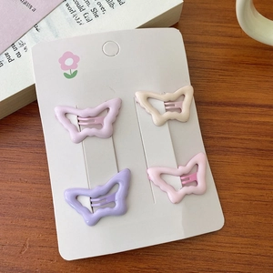 Detailansicht der Schmetterling-Haarspangen in Pastellrosa und Violett auf Displaykarte