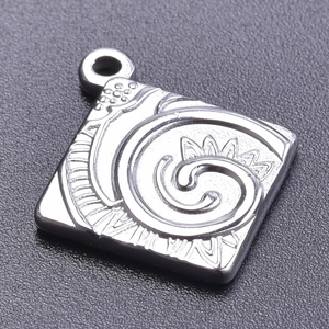 Macro shot of a silver square stainless steel pendant with vortex textured patterns